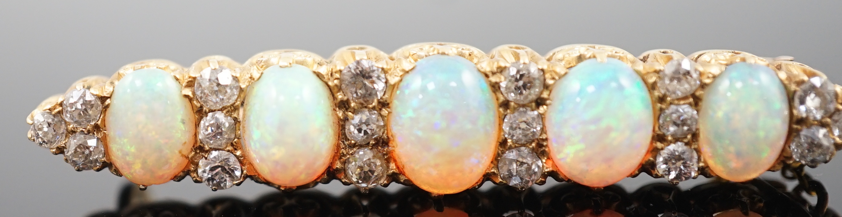 An early 20th century gold, diamond and oval white opal cluster set clip bar brooch